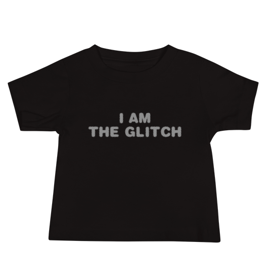 "I am the glitch" printed on a black baby jersey short sleeve tee laying on a flat surface