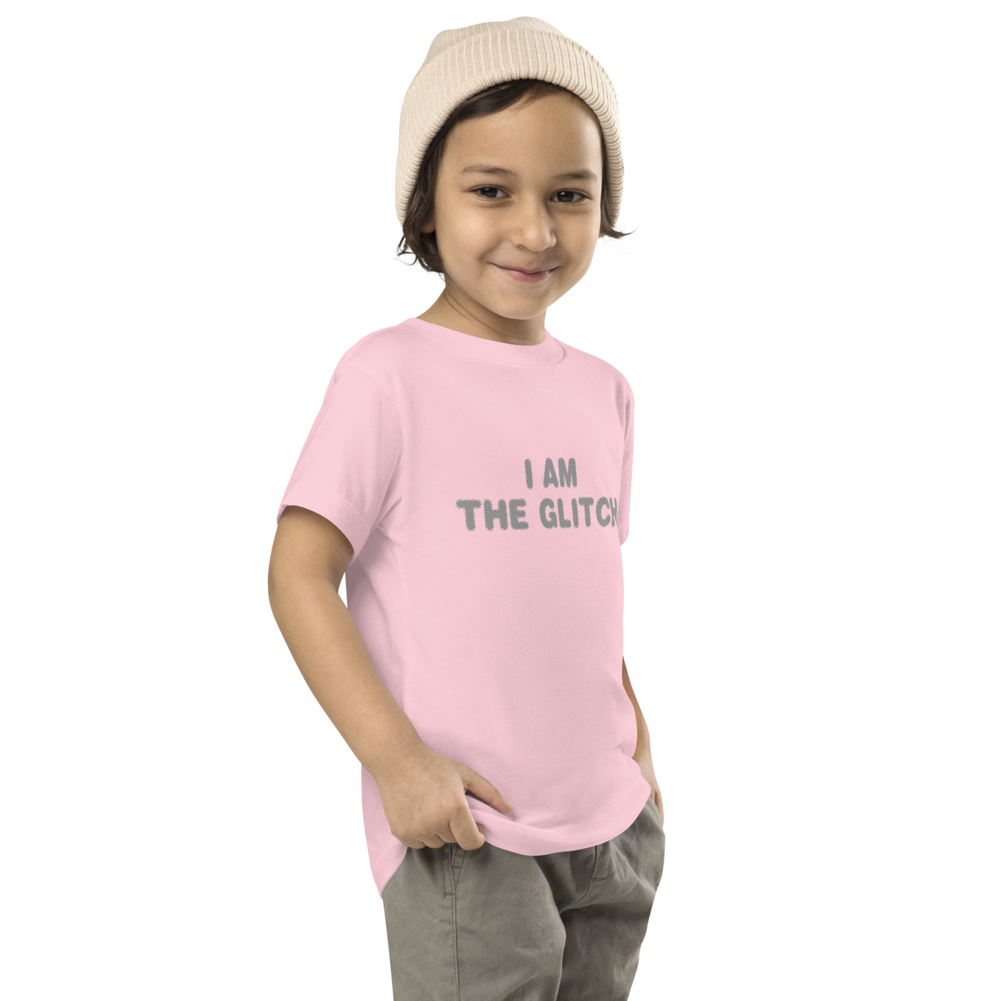 "I am the glitch" printed on a pink toddler short sleeve tee worn by a male who is also wearing a knit cap