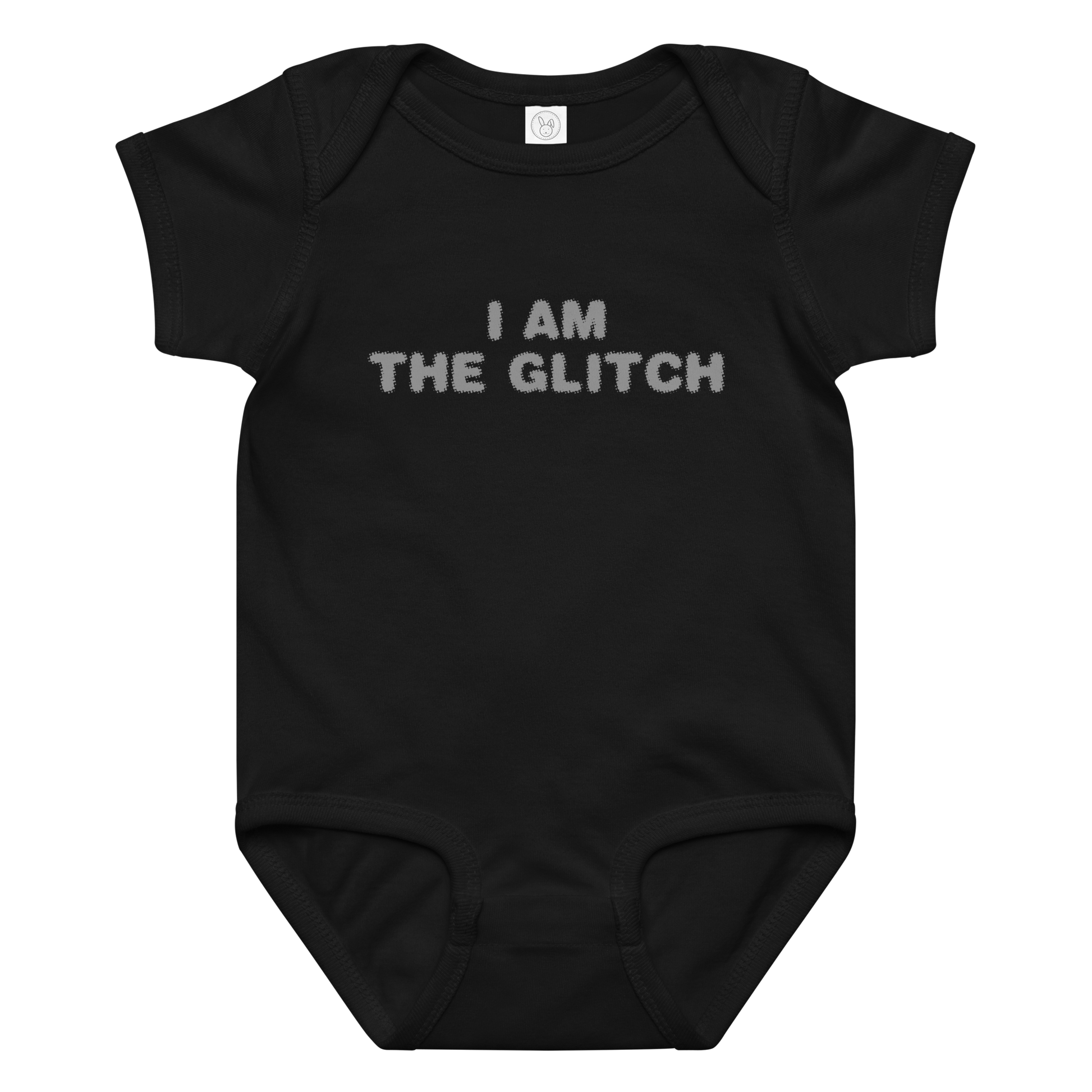 "I am the glitch" printed on a black baby jersey bodysuit laying on a flat surface amongst other clothes