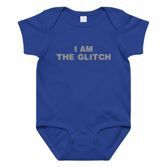 "I am the glitch" printed on a royal baby jersey bodysuit laying on a flat surface amongst other clothes