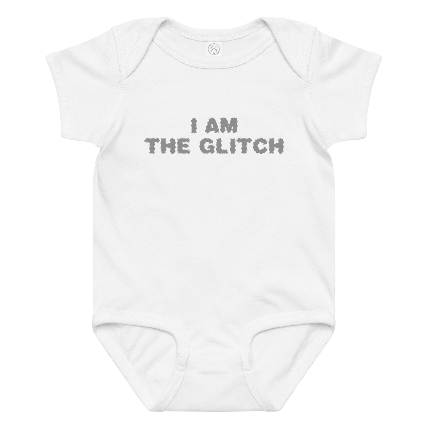 "I am the glitch" printed on a white baby jersey bodysuit laying on a flat surface amongst other clothes