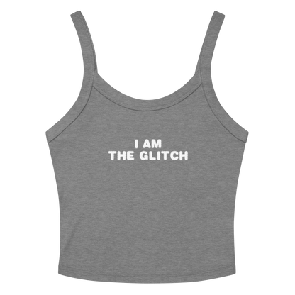 "I am the glitch" printed on a athletic heather women's micro-rib tanktop laying on a flat surface amongst sunglasses and shorts