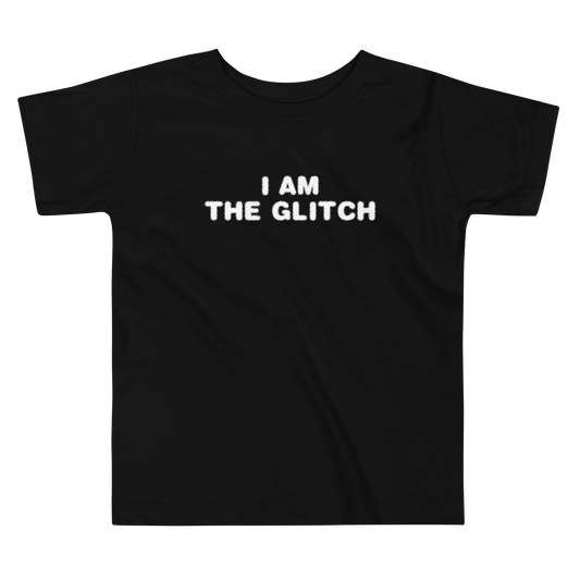 "I am the glitch" printed on a black toddler short sleeve tee laying on a flat surface