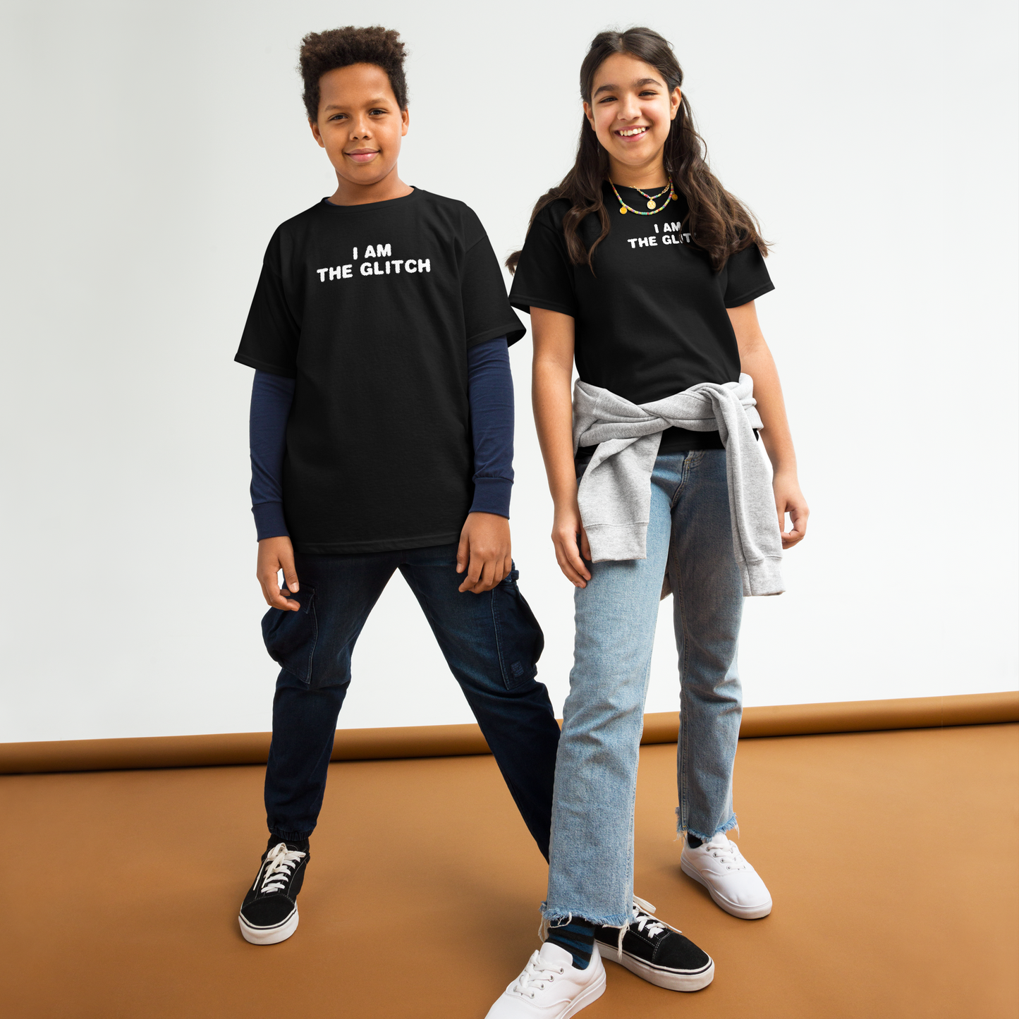 "I am the glitch" printed on a black youth classic tee worn by a female and male