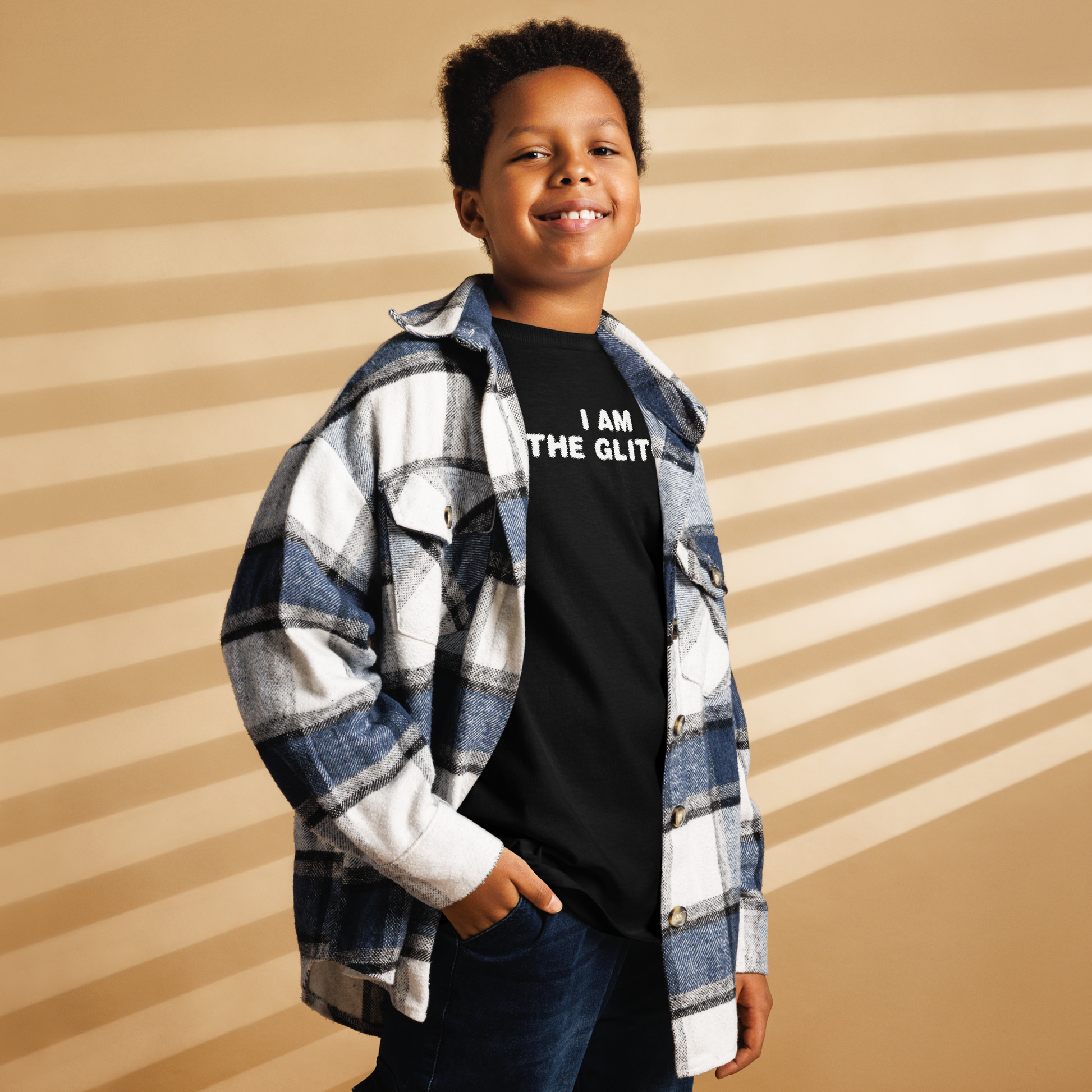 "I am the glitch" printed on a black youth classic tee worn by a male also wearing a jacket