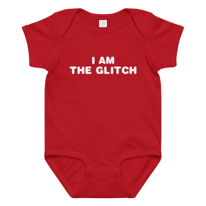 "I am the glitch" printed on a red baby jersey bodysuit laying on a flat surface amongst other clothes