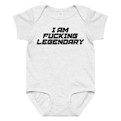 "I Am Fucking Legendary" printed on a ash baby jersey bodysuit laying on a flat surface amongst other clothes