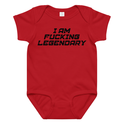 "I Am Fucking Legendary" printed on a red baby jersey bodysuit laying on a flat surface amongst other clothes