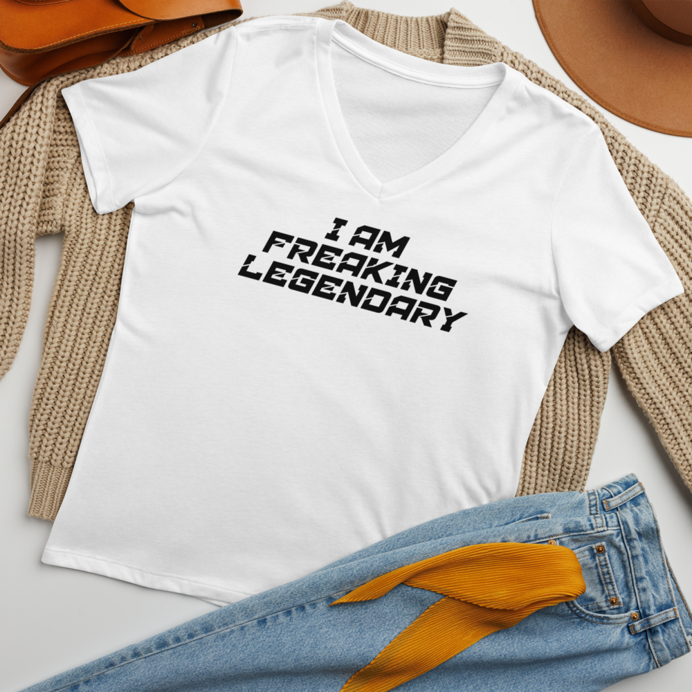 "I Am Freaking Legendary" printed on a solid white blend women's relaxed v-neck t-shirt laying on a flat surface amongst other clothes