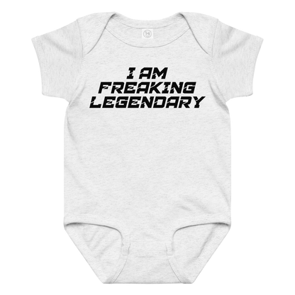 "I Am Freaking Legendary" printed on a ash baby jersey bodysuit laying on a flat surface amongst other clothes