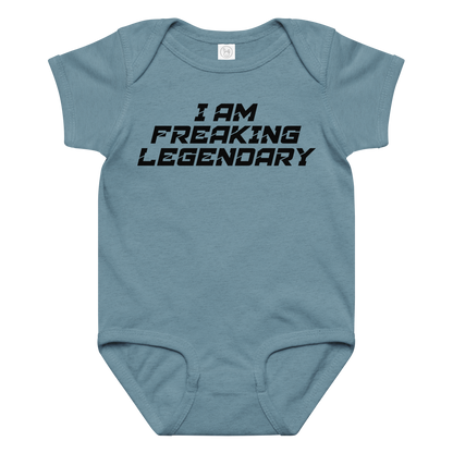 "I Am Freaking Legendary" printed on a vintage indigo baby jersey bodysuit laying on a flat surface amongst other clothes