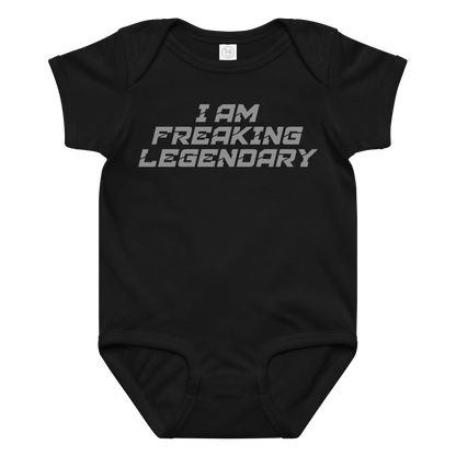 "I Am Freaking Legendary" printed on a black baby jersey bodysuit laying on a flat surface amongst other clothes