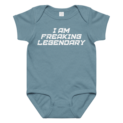 "I Am Freaking Legendary" printed on a vintage indigo baby jersey bodysuit laying on a flat surface amongst other clothes