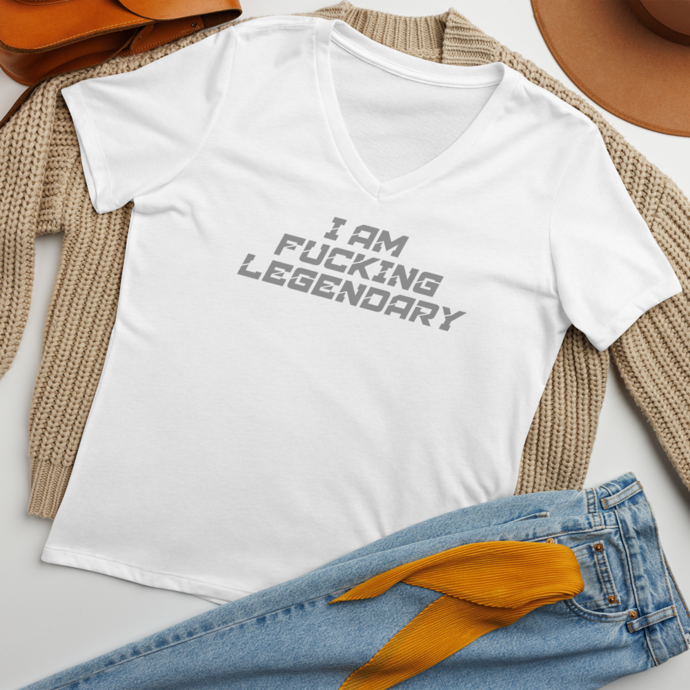 "I Am Fucking Legendary" printed on a solid white blend women's relaxed v-neck t-shirt laying on a flat surface amongst other clothes