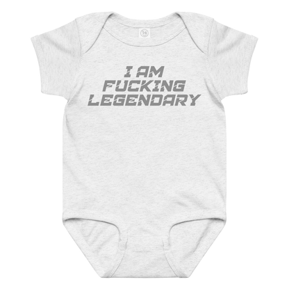 "I Am Fucking Legendary" printed on a ash baby jersey bodysuit laying on a flat surface amongst other clothes