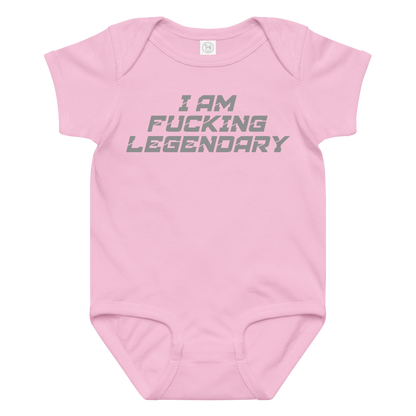 "I Am Fucking Legendary" printed on a pink baby jersey bodysuit laying on a flat surface amongst other clothes