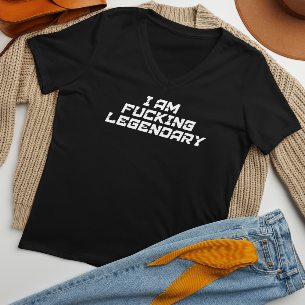 "I Am Fucking Legendary" printed on a solid black blend women's relaxed v-neck t-shirt laying on a flat surface amongst other clothes