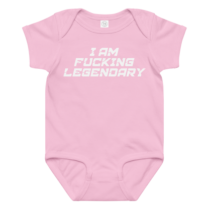 "I Am Fucking Legendary" printed on a pink baby jersey bodysuit laying on a flat surface amongst other clothes