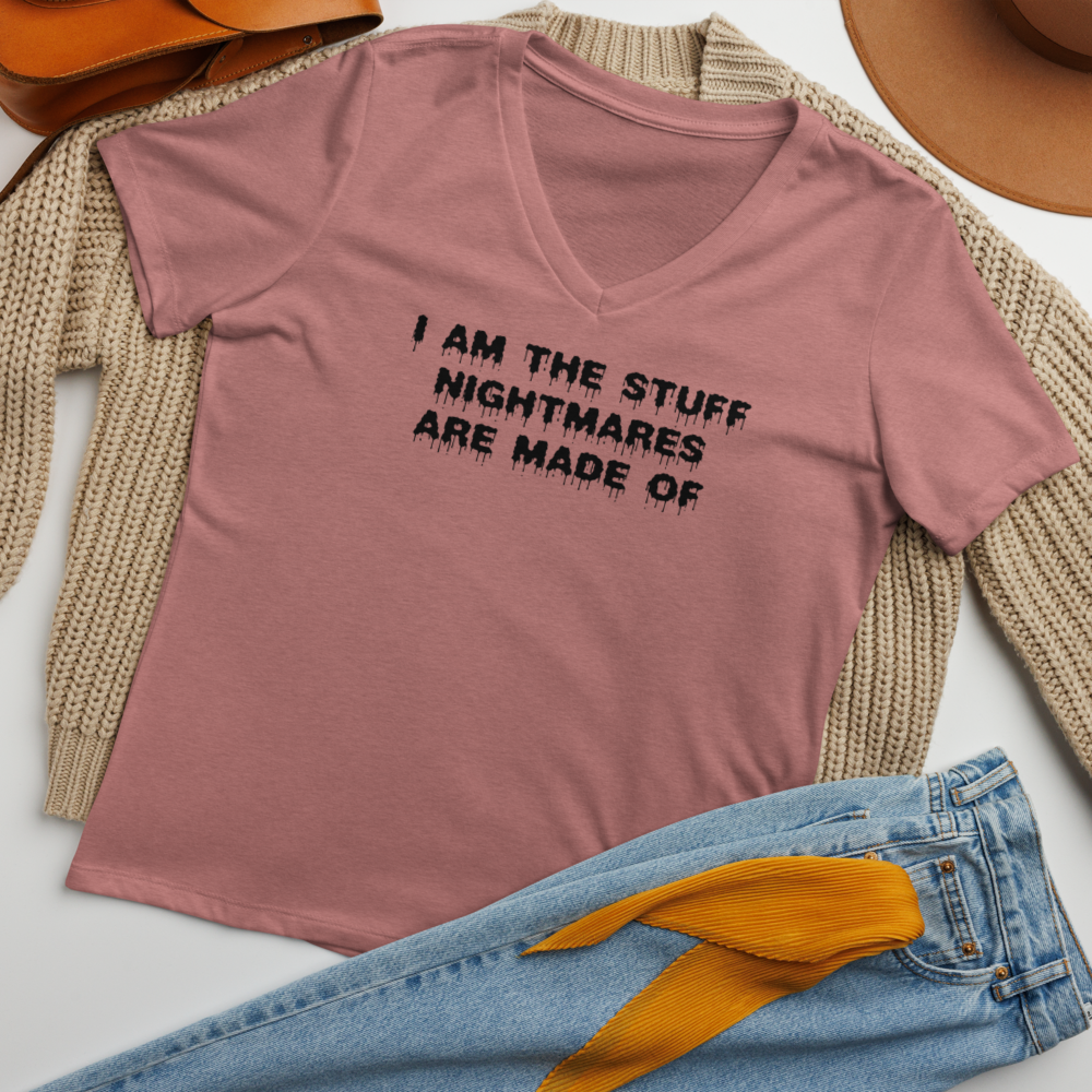 "I am the stuff nightmares are made of" printed on a heather mauve women's relaxed v-neck t-shirt laying on a flat surface amongst other clothes