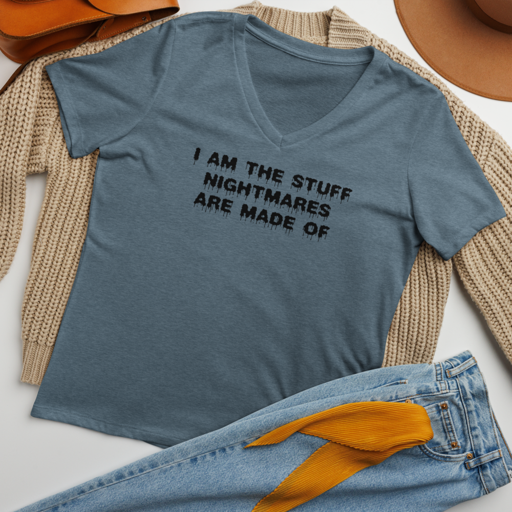 "I am the stuff nightmares are made of" printed on a heather slate women's relaxed v-neck t-shirt laying on a flat surface amongst other clothes