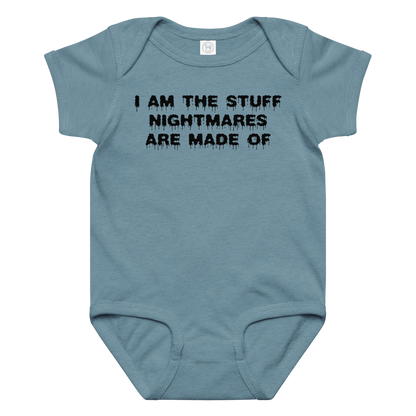 "I am the stuff nightmares are made of" printed on a vintage indigo baby jersey bodysuit laying on a flat surface amongst other clothes