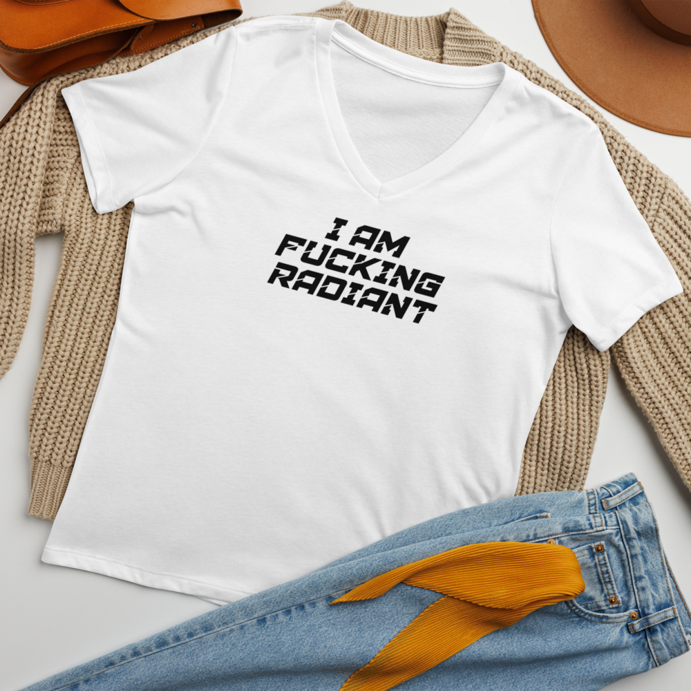 "I Am Fucking Radiant" printed on a solid white blend women's relaxed v-neck t-shirt laying on a flat surface amongst other clothes