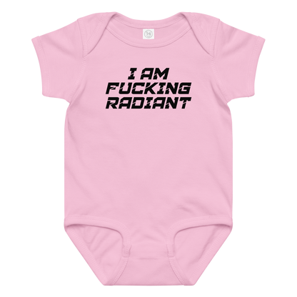 "I Am Fucking Radiant" printed on a pink baby jersey bodysuit laying on a flat surface amongst other clothes