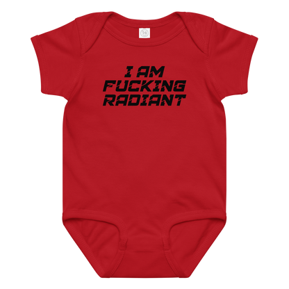 "I Am Fucking Radiant" printed on a red baby jersey bodysuit laying on a flat surface amongst other clothes