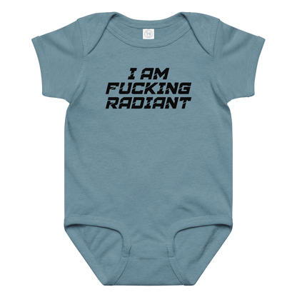 "I Am Fucking Radiant" printed on a vintage indigo baby jersey bodysuit laying on a flat surface amongst other clothes