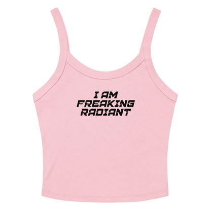 "I Am Freaking Radiant" printed on a solid pink blend women's micro-rib tanktop laying on a flat surface amongst sunglasses and shorts