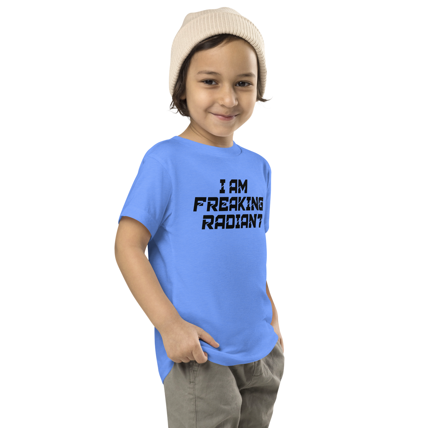 "I Am Freaking Radiant" printed on a heather columbia blue toddler short sleeve tee worn by a male who is also wearing a knit cap
