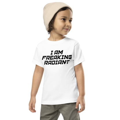 "I Am Freaking Radiant" printed on a white toddler short sleeve tee worn by a male wearing a cap
