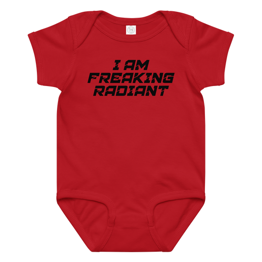 "I Am Freaking Radiant" printed on a red baby jersey bodysuit laying on a flat surface amongst other clothes