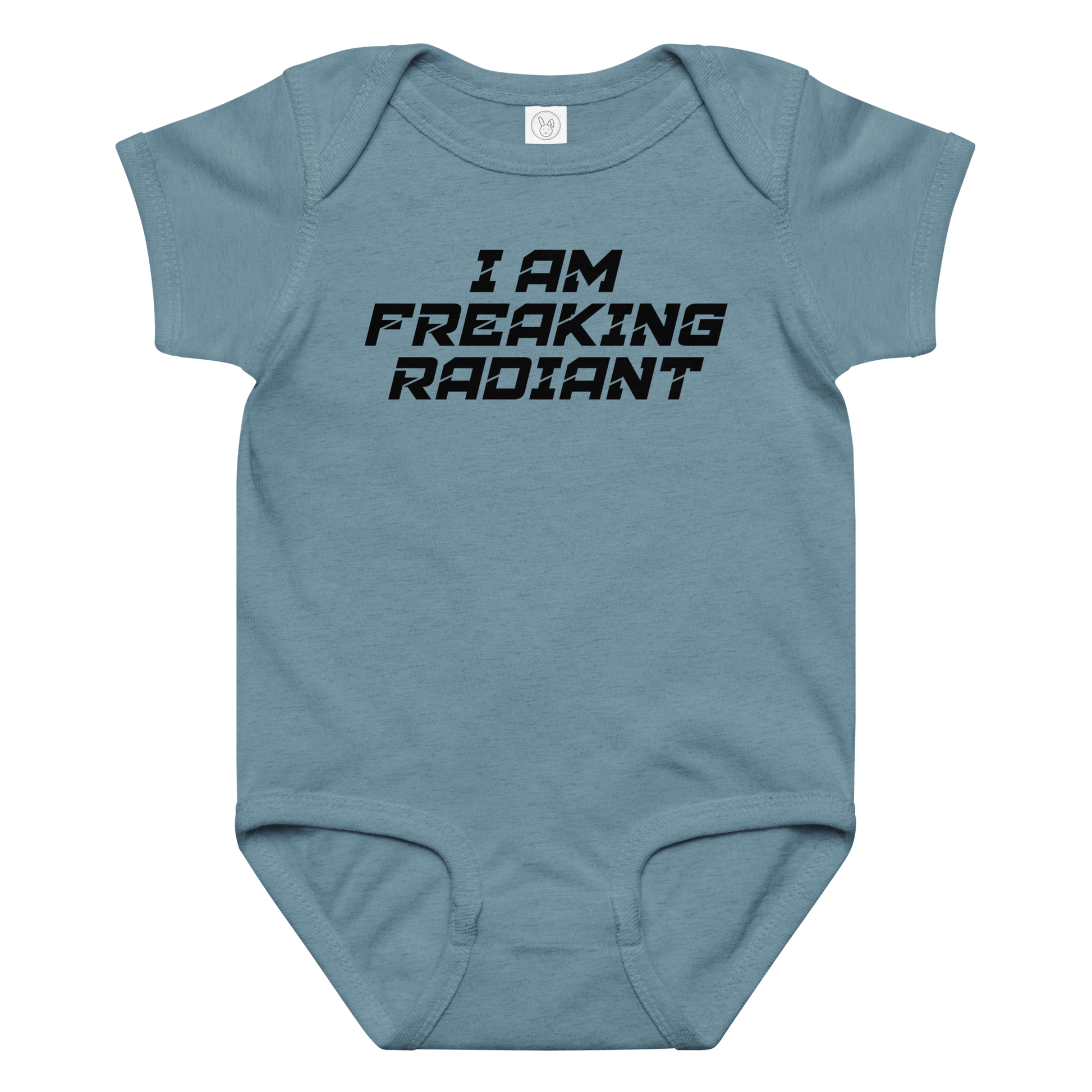 "I Am Freaking Radiant" printed on a vintage indigo baby jersey bodysuit laying on a flat surface amongst other clothes