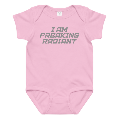 "I Am Freaking Radiant" printed on a pink baby jersey bodysuit laying on a flat surface amongst other clothes