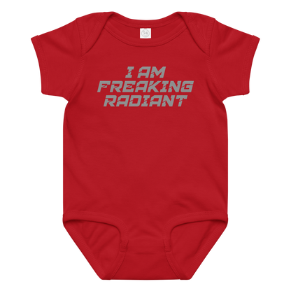 "I Am Freaking Radiant" printed on a red baby jersey bodysuit laying on a flat surface amongst other clothes