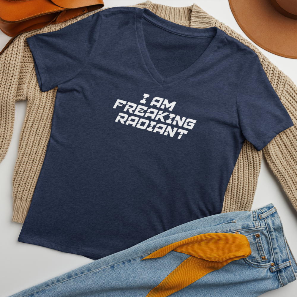 "I Am Freaking Radiant" printed on a heather navy women's relaxed v-neck t-shirt laying on a flat surface amongst other clothes