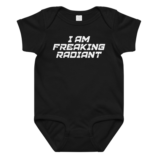 "I Am Freaking Radiant" printed on a black baby jersey bodysuit laying on a flat surface amongst other clothes