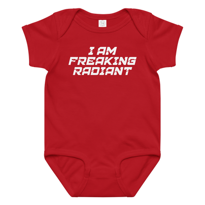 "I Am Freaking Radiant" printed on a red baby jersey bodysuit laying on a flat surface amongst other clothes
