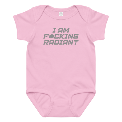 "I Am F*cking Radiant" printed on a pink baby jersey bodysuit laying on a flat surface amongst other clothes