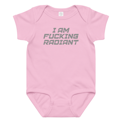 "I Am Fucking Radiant" printed on a pink baby jersey bodysuit laying on a flat surface amongst other clothes