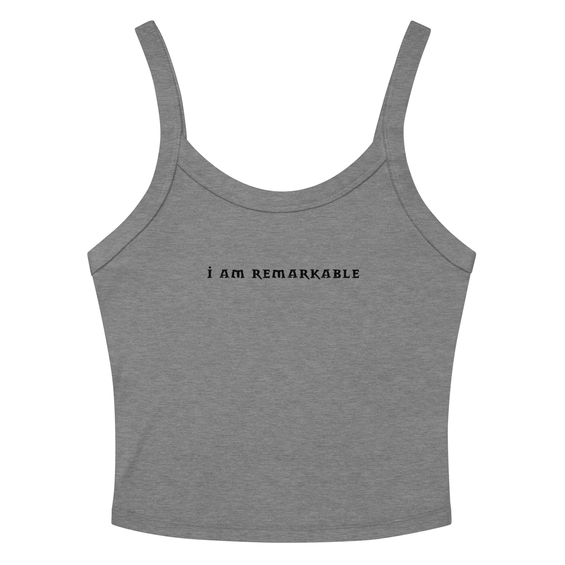 "I am remarkable" printed on a athletic heather women's micro-rib tanktop laying on a flat surface amongst sunglasses and shorts