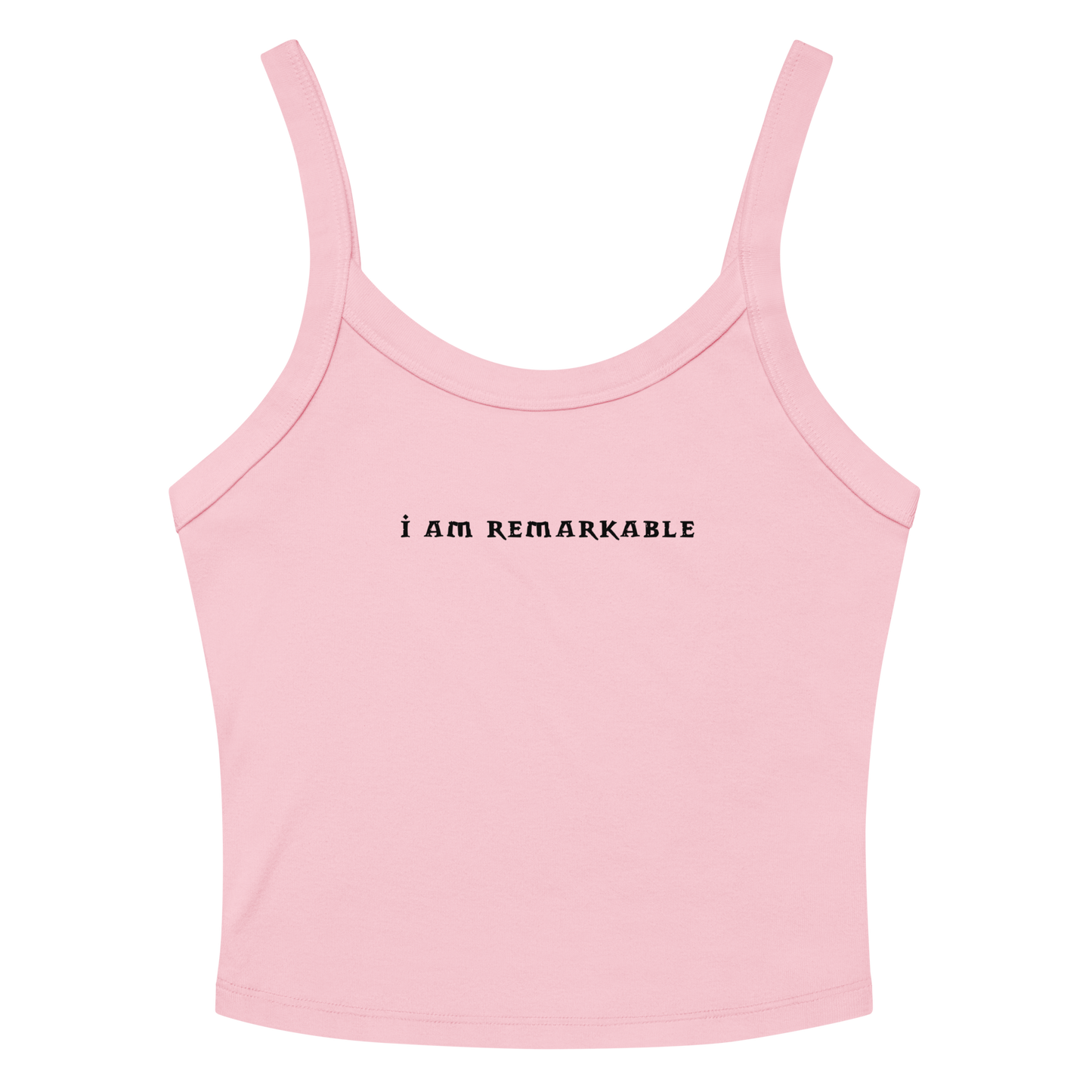 "I am remarkable" printed on a solid pink blend women's micro-rib tanktop laying on a flat surface amongst sunglasses and shorts