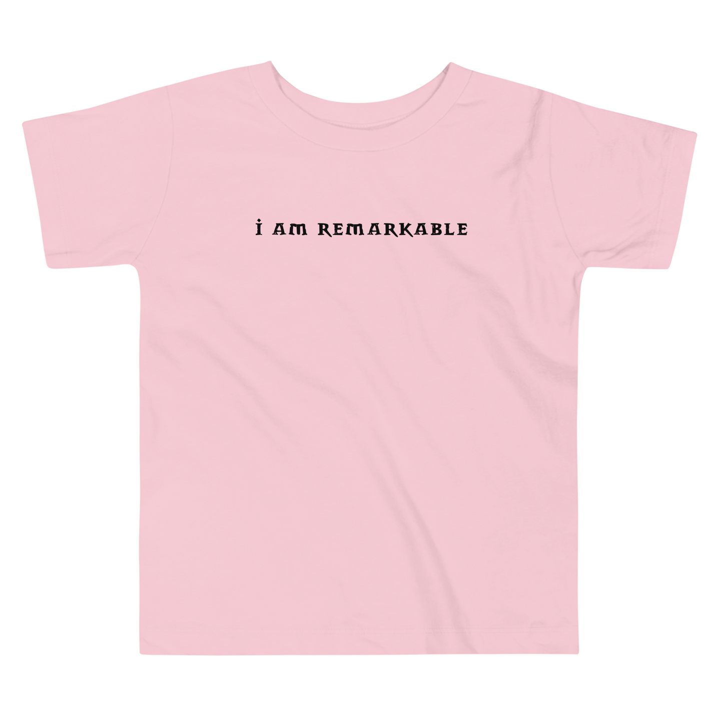 "I am remarkable" printed on a pink toddler short sleeve tee laying on a flat surface