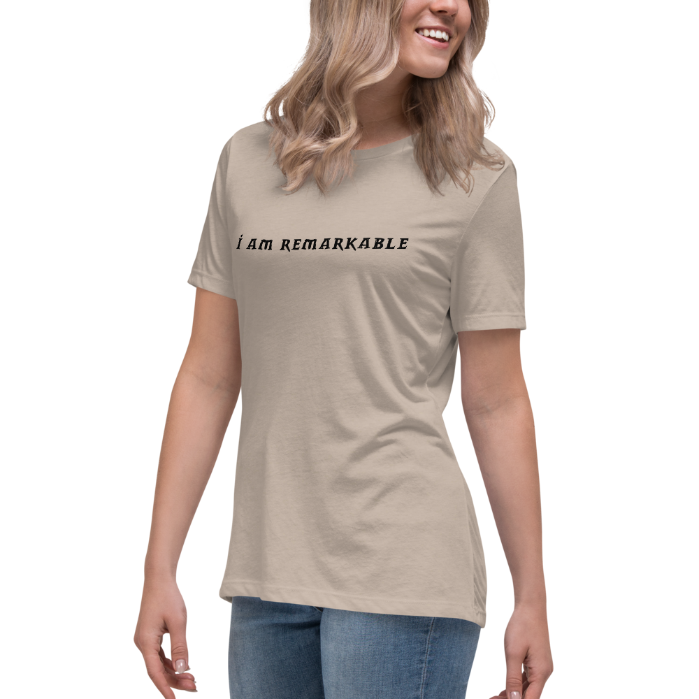 "I am remarkable" printed on a heather stone women's relaxed t-shirt worn by a female