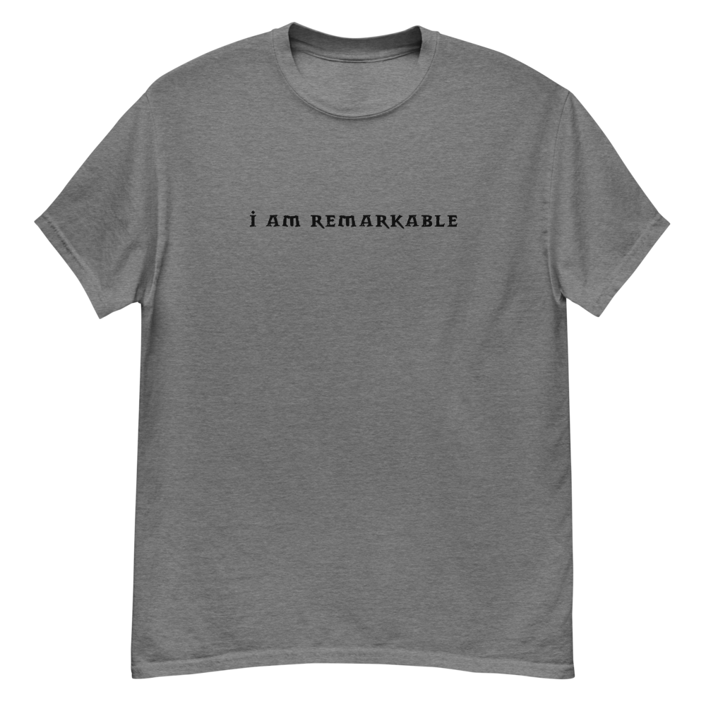 "I am remarkable" printed on a graphite heather unisex classic tee laying on a flat surface