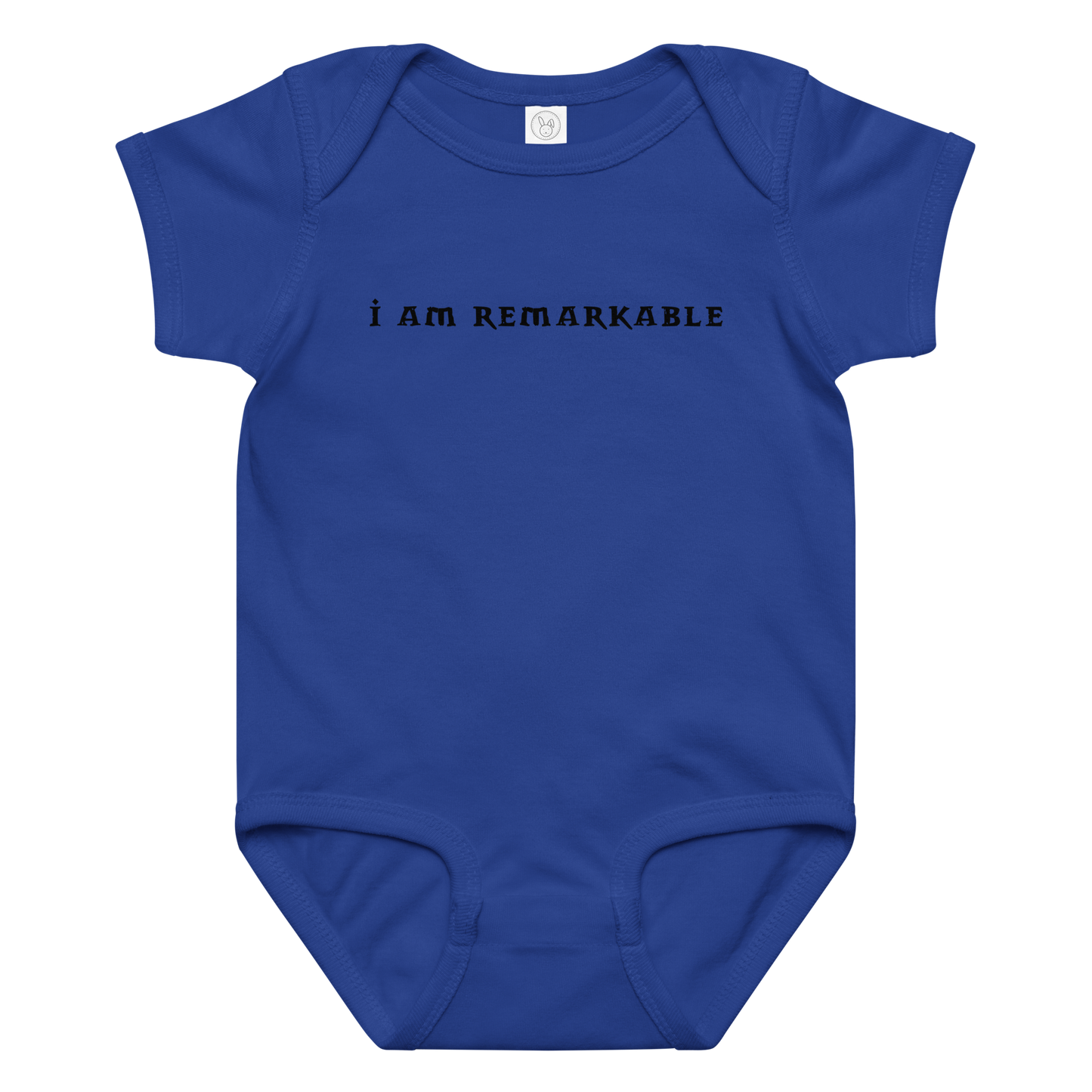 "I am remarkable" printed on a royal baby jersey bodysuit laying on a flat surface amongst other clothes