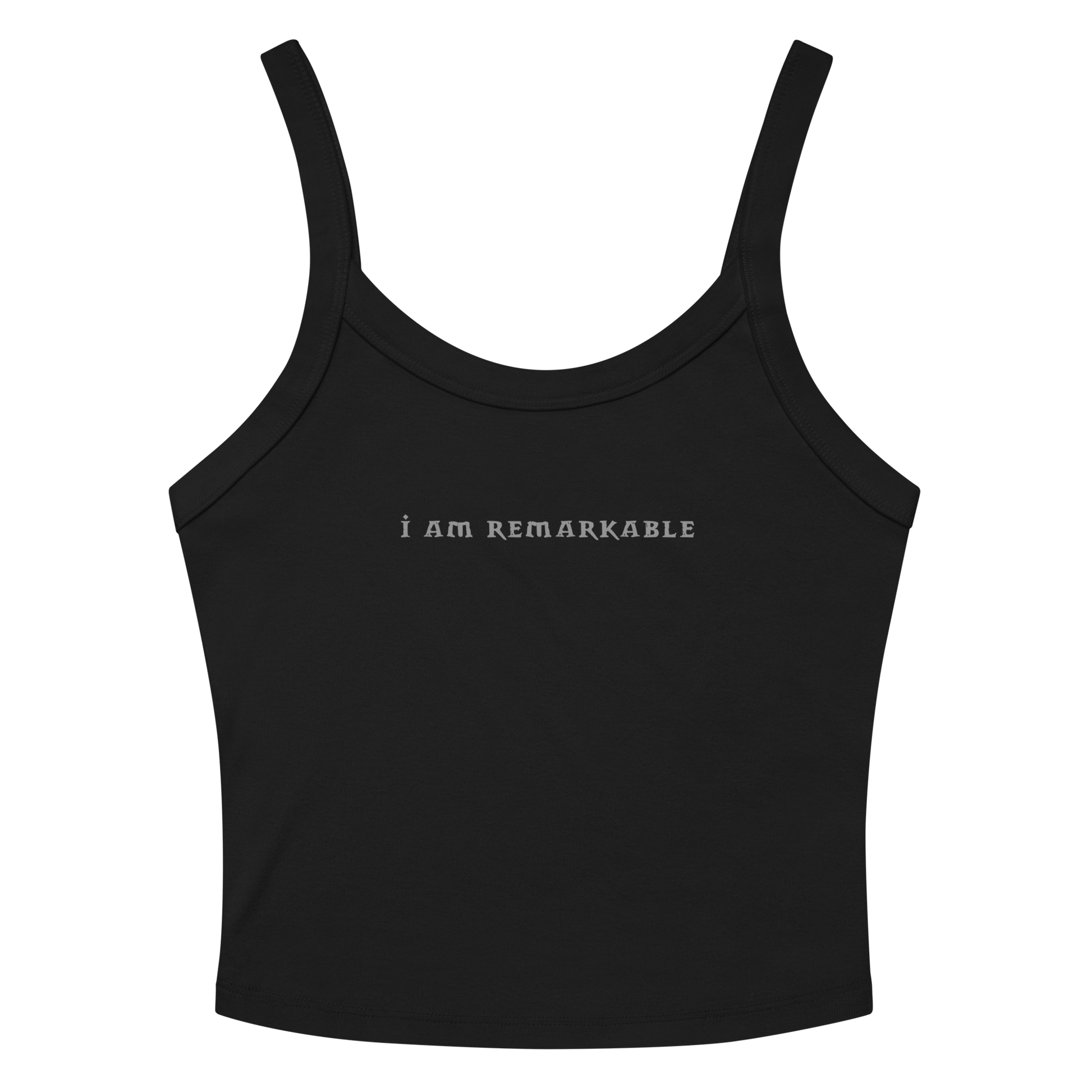 "I am remarkable" printed on a solid black blend women's micro-rib tanktop laying on a flat surface amongst sunglasses and shorts