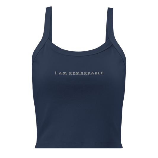 "I am remarkable" printed on a solid navy blend women's micro-rib tanktop laying on a flat surface