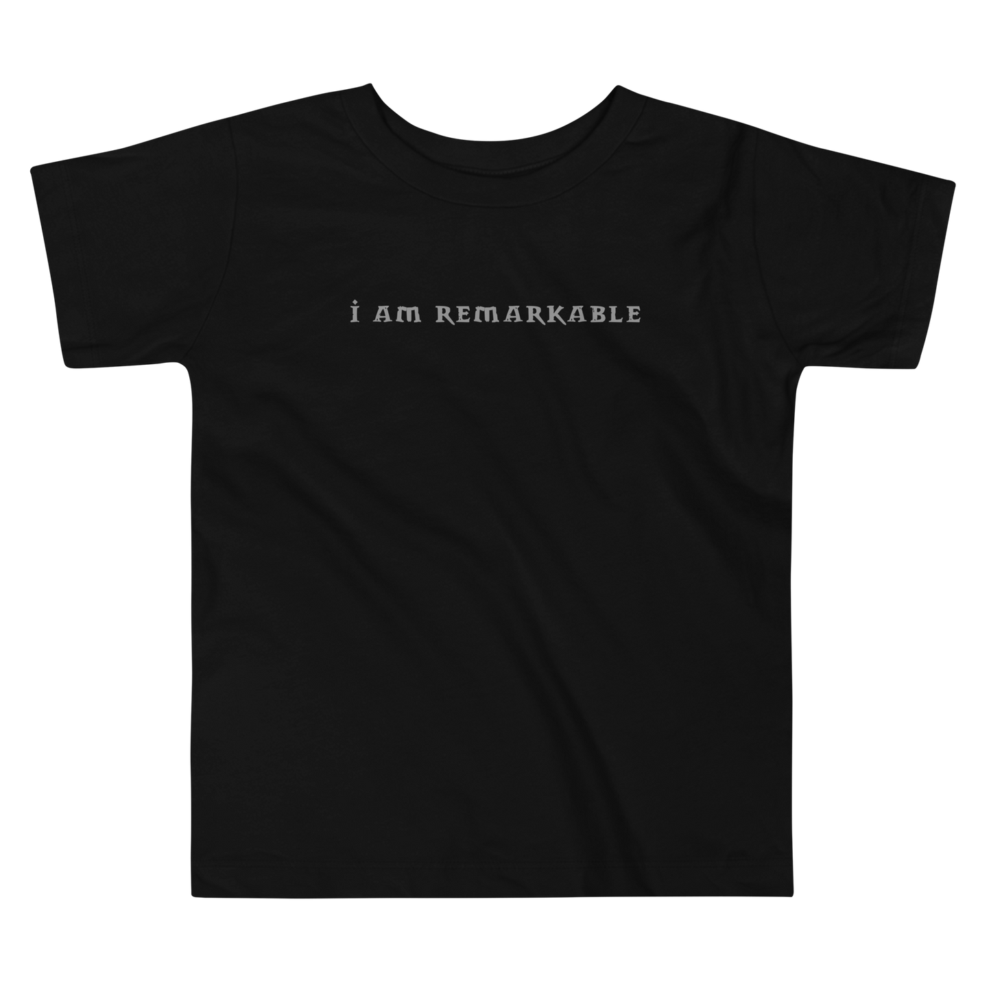 "I am remarkable" printed on a black toddler short sleeve tee laying on a flat surface